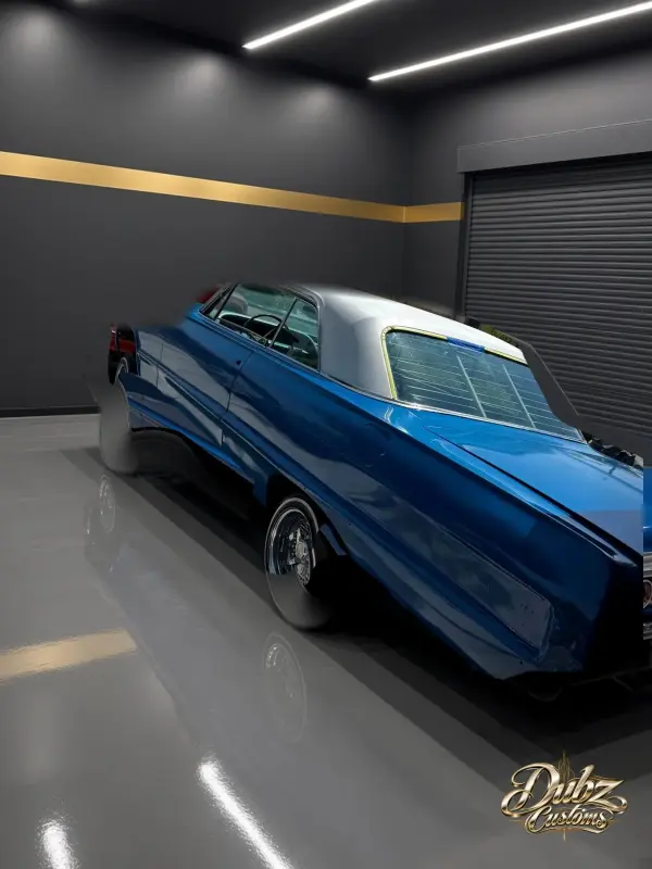 Blue 1964 Chevrolet Impala with a white top on wire wheels