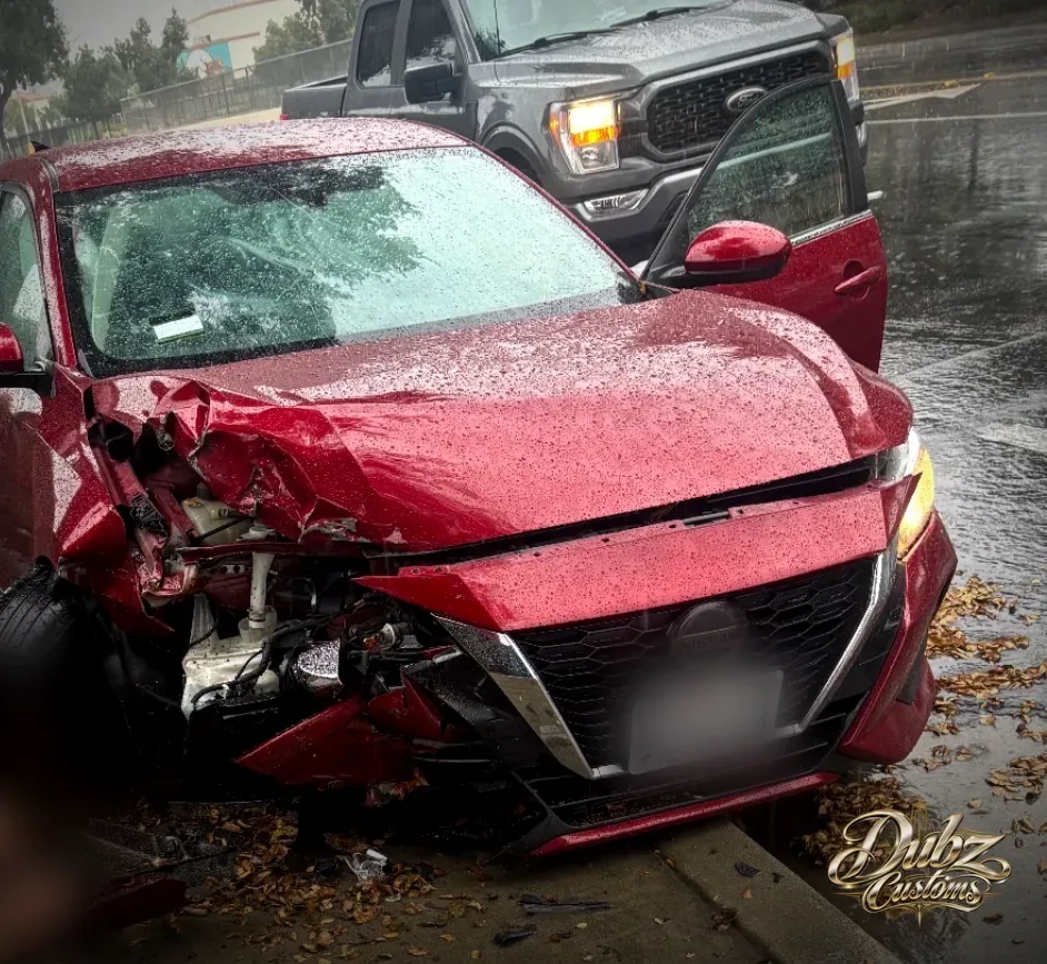 Red 2022 Nissan with a crushed front end after a collision